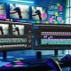 Social-Media-Creator an modernem Editing-Setup mit mehreren Monitoren, auf denen vertikale Instagram Reel-Loops, Audio-Wellenformen und Farbkorrekturtools zu sehen sind, im Hintergrund bunte Moodboards und Pflanzen.