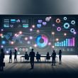 Business-Team vor großem Echtzeit-Dashboard im modernen, minimalistischen Büro mit interaktiven Diagrammen und vernetzten Datenquellen.