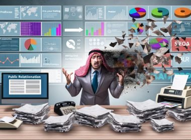 Moderner Arbeitsplatz mit gestresstem PR-Experten, alte Presseunterlagen weichen digitalen Bildschirmen mit Newsfeeds und Analysen.