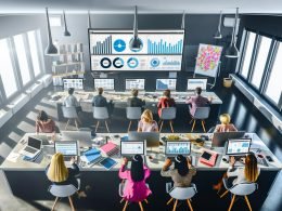 Vogelperspektive auf ein modernes PR-Büro mit mehreren Expert:innen, die an Laptops und großen Monitoren mit Dashboards, Medienmonitoring und Pressemitteilungen arbeiten.
