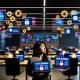 Marketer in modernem Großraumbüro blickt kritisch auf Datenschutz-Banner vor Monitoren mit Dashboards und digitalen Bedrohungssymbolen im Jahr 2025.