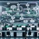 Futuristischer Büroraum mit riesiger transparenter Leinwand, die ein Automation-Flowchart zeigt. Im Hintergrund Marketer an Workstations mit digitalen Dashboards und Echtzeit-Performance-Grafiken.