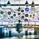 Ein moderner Marketing-Profi im lichtdurchfluteten Büro vor Monitoren mit Themenclustern, SEO-Dashboards und strategischer Planung. Whiteboard mit Begriffen wie Semantik und E-E-A-T im Hintergrund.