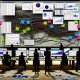 Chaotisch verstellter Schreibtisch mit mehreren Monitoren, überlappenden Dashboards, verstreuten Notizen und einer beleuchteten klaren Datenpipeline im Hintergrund.