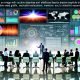Geschäftsleute analysieren komplexe, interaktive Datendarstellungen an einem High-Tech-Touchscreen im modernen Büro mit vernetzten Digitalbildschirmen.