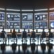 Hightech-Kontrollraum mit Marketers und Analysten vor Bildschirmen mit Live-Daten, Conversion-Charts, A/B-Test-Ergebnissen und einem leuchtenden Taboola-Logo.