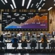 Dynamisches Online-Marketing-Team in modernem Start-up-Büro mit Monitoren, die Umsatzdiagramme, Heatmaps, Conversion-Funnel und SEO-Begriffe zeigen.