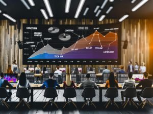 Dynamisches Online-Marketing-Team in modernem Start-up-Büro mit Monitoren, die Umsatzdiagramme, Heatmaps, Conversion-Funnel und SEO-Begriffe zeigen.