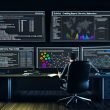 Moderner, dunkler Arbeitsplatz mit drei großen Bildschirmen mit komplexen SEO-Analysen – technische Reports, Themencluster, Heatmaps, Netzwerk-Visualisierungen – sowie einer sachlich wirkenden, konzentrierten Person mit Notizbuch.
