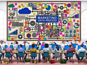 Vielseitiges Marketingteam arbeitet in einem futuristisch eingerichteten Büro an digitalen Dashboards mit großen Screens voller Marketingdaten, Touchpoints und Analytics.