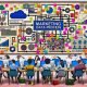 Chaotisches Büro mit verstreuten Tabellen, bunten Post-its, Kaffeetassen und einer beschrifteten Tafel, auf der Marketing Daten Prozesse und digitale Symbole wie Cloud und KI zu sehen sind.
