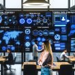 Marketing-Team diskutiert vor großem Data Dashboard mit verschiedenen Datenquellen und Whiteboards in einem offenen, modernen Büro.