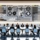 Digitales Marketing-Team analysiert Performance-Kennzahlen, Datenquellen und APIs an leuchtenden Dashboards in einem modernen Büro.