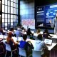 Urbaner Seminarraum mit großen Fenstern, engagierte Menschen diskutieren vor Monitor mit SEO-Dashboard, Post-Its und Whiteboards mit technischen Skizzen – Seminarleiter zeigt dynamisch auf Core Web Vitals.