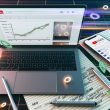 Moderner Arbeitsplatz mit Laptop und YouTube-Analytics Dashboard, umgeben von Notizen, Markern, Smartphone mit erfolgreich gepostetem Video und leuchtenden Datenströmen.