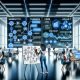 Marketing-Team im modernen Büro mit Live-Dashboards, das Tracking-Fahrplan markiert. Datenströme verbinden verschiedene Kanäle mit zentralem Data Warehouse.
