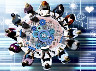 Dynamische Illustration von modernen Bloggern, die kreativ an einem großen runden Tisch mit Laptops und Tablets arbeiten, im Zentrum ein Content-Plan mit Notizen, Grafiken und digitalen Netzwerken zu verschiedenen Plattformen.