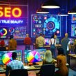 Urban gekleidete Marketer und SEO-Experten analysieren in einem modernen Workspace vor riesigen Monitoren SEO-Heatmaps und Datengrafiken. Im Hintergrund leuchtet ein provokanter Screen mit dem Titel 'SEO Jun True Beauty'.