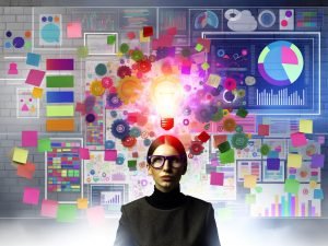 Kreative Person mit trendiger Brille arbeitet am Moodboard, bunte Notizen und Entwürfe, dahinter leuchtende digitale Analytics-Elemente und Diagramme.