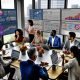 Modernes Marketingbüro mit diversen Teammitgliedern, digitalen Dashboards, Datenanalysen und engagierter Strategiearbeit.
