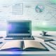 Moderner minimalistischer Schreibtisch mit Laptop, Notizbuch, Stiften, Post-its sowie digitalen SEO-Grafiken und Content-Clustern im Hintergrund.