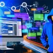 Stylischer Joomla-Anwender vor Computer mit Joomla-Backend und SEO-Diagrammen, urbaner Hintergrund mit digitalen SEO-Icons.