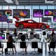 Modernes Marketingbüro mit diversen Experten an Computern, Visualisierung von Daten-Dashboards und Diagrammen, roter Ferrari mit offenem Motorraum und leerem Tank im Mittelpunkt – Sinnbild für das Potenzial von Daten im Marketing.