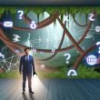 Geschäftsmann im Anzug mit Taschenlampe vor einem digitalen Labyrinth aus Social-Media-Icons, Werbebannern und Analysezahlen.