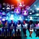 Vielfältige Gruppe von Digitalmarketer:innen und Blogger:innen netzwerken in einer modernen Umgebung mit digitalen Geräten und Marken-Icons.