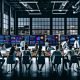 Junge Profis bei einem intensiven SEO-Strategieworkshop in einem industriellen Raum mit Analyse-Dashboards und Großstadtblick.