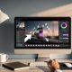 Moderner Arbeitsplatz mit Laptop, der einen KI-Fotoeditor im Browser zeigt (Hintergrund entfernen, Inpainting, Upscaling, generatives Füllen); Designerhände mit Maus und Stylus, Farbfächer, Notizbücher, Smartphone, Kaffee und Pflanze; Cloud-UI mit Export nach WebP/AVIF.