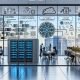 Modernes KI‑Büro: diverse Teams vor Screens mit Datenpipelines, neuronalen Netzen, Live‑Metriken, CI/CD‑Pipelines und Compliance‑Hinweisen (EU AI Act, DSGVO).