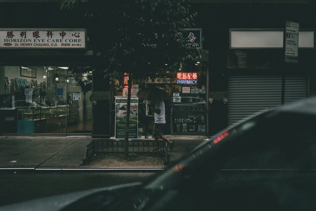 menschen-die-nachts-auf-dem-burgersteig-in-der-nahe-des-gebaudes-spazieren-gehen-NqC8f7y0qqM