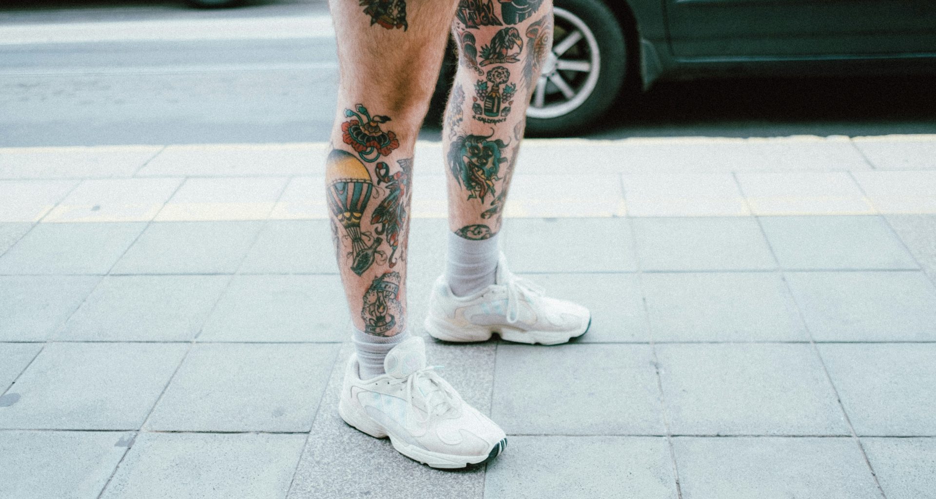 person-in-blauen-jeansshorts-und-weissen-nike-sneakers-auf-grauem-betonboden-ON5LEOUtVJ0