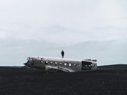 person-die-auf-zerquetschtem-flugzeug-steht-xF5q0NHTe8s