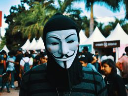 person-die-tagsuber-eine-guy-fawkes-maske-in-der-nahe-von-menschen-tragt-wK3WaYrHEBM