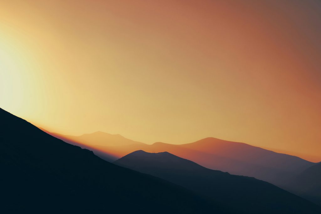 die-sonne-geht-uber-einer-bergkette-unter-J5mtEGpkOEU