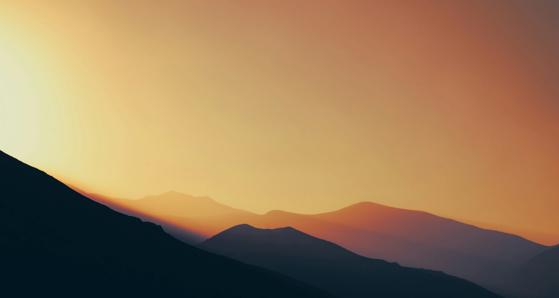 die-sonne-geht-uber-einer-bergkette-unter-J5mtEGpkOEU
