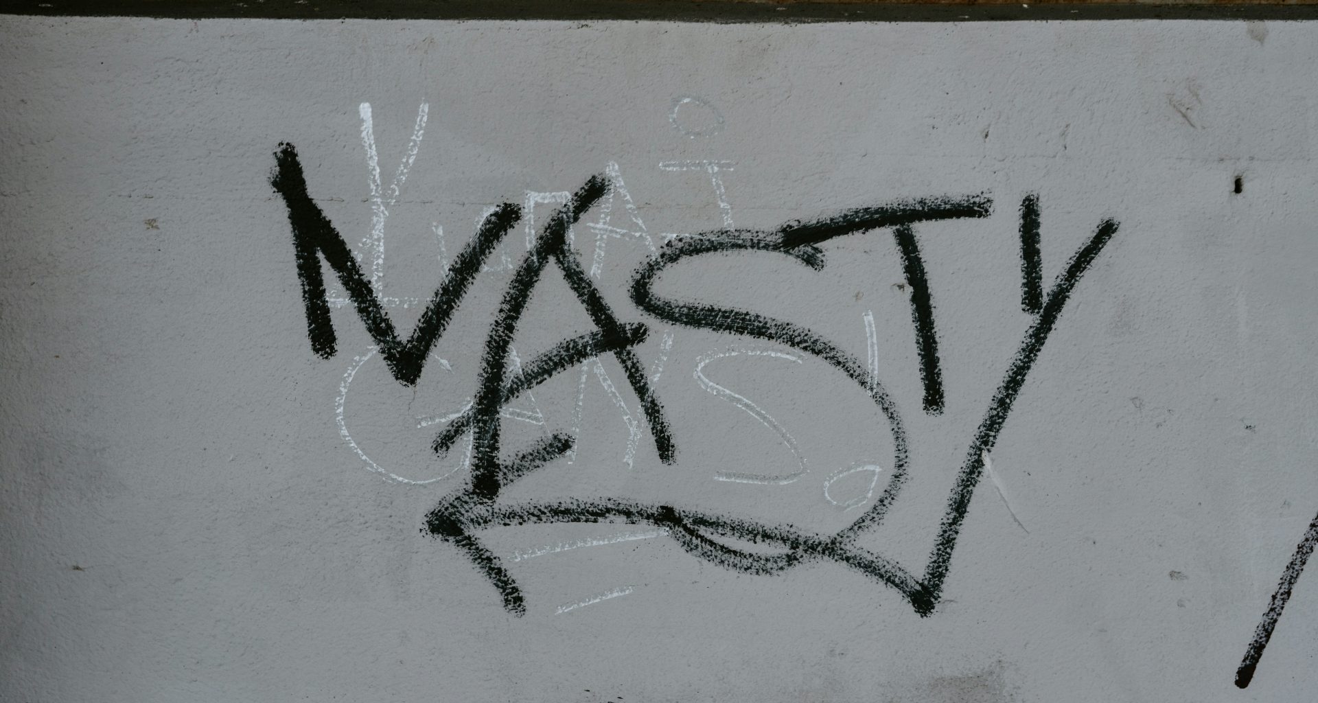 vandalismus-an-weiss-gestrichener-wand-wY6SoMOtWws