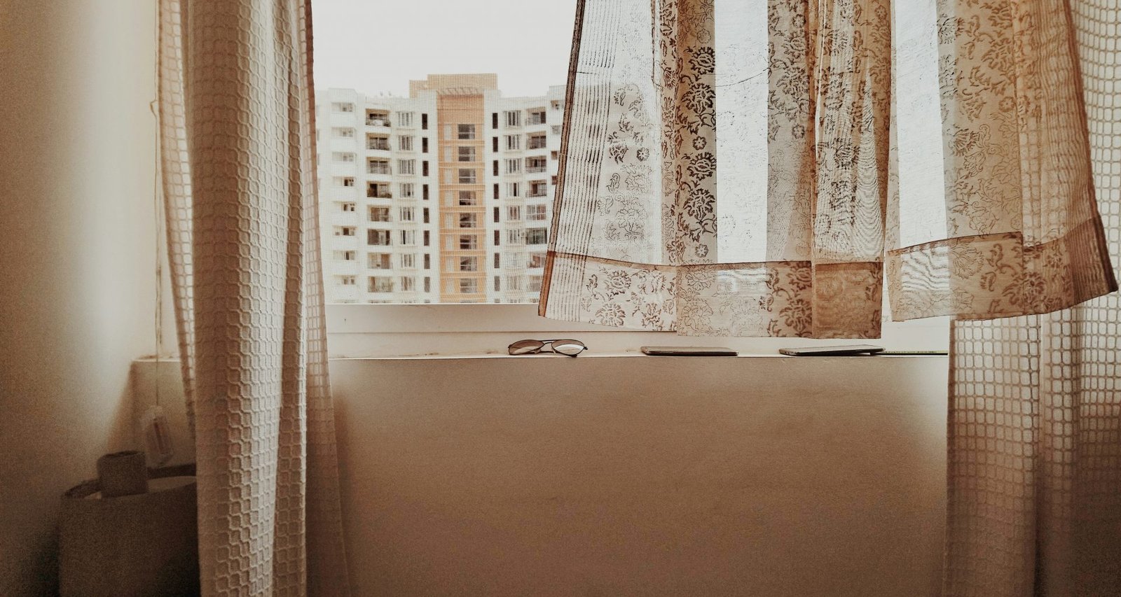 weisses-und-braunes-gebaude-das-tagsuber-durch-ein-fenster-sieht-0berjRl2uks