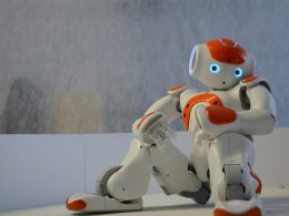 weisser-und-orangefarbener-roboter-in-der-nahe-der-wand-yLcK3Itx6ok