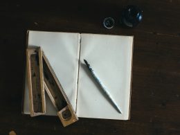 weisser-fullfederhalter-auf-weissem-offenem-buch-9P7WD1dU5VQ