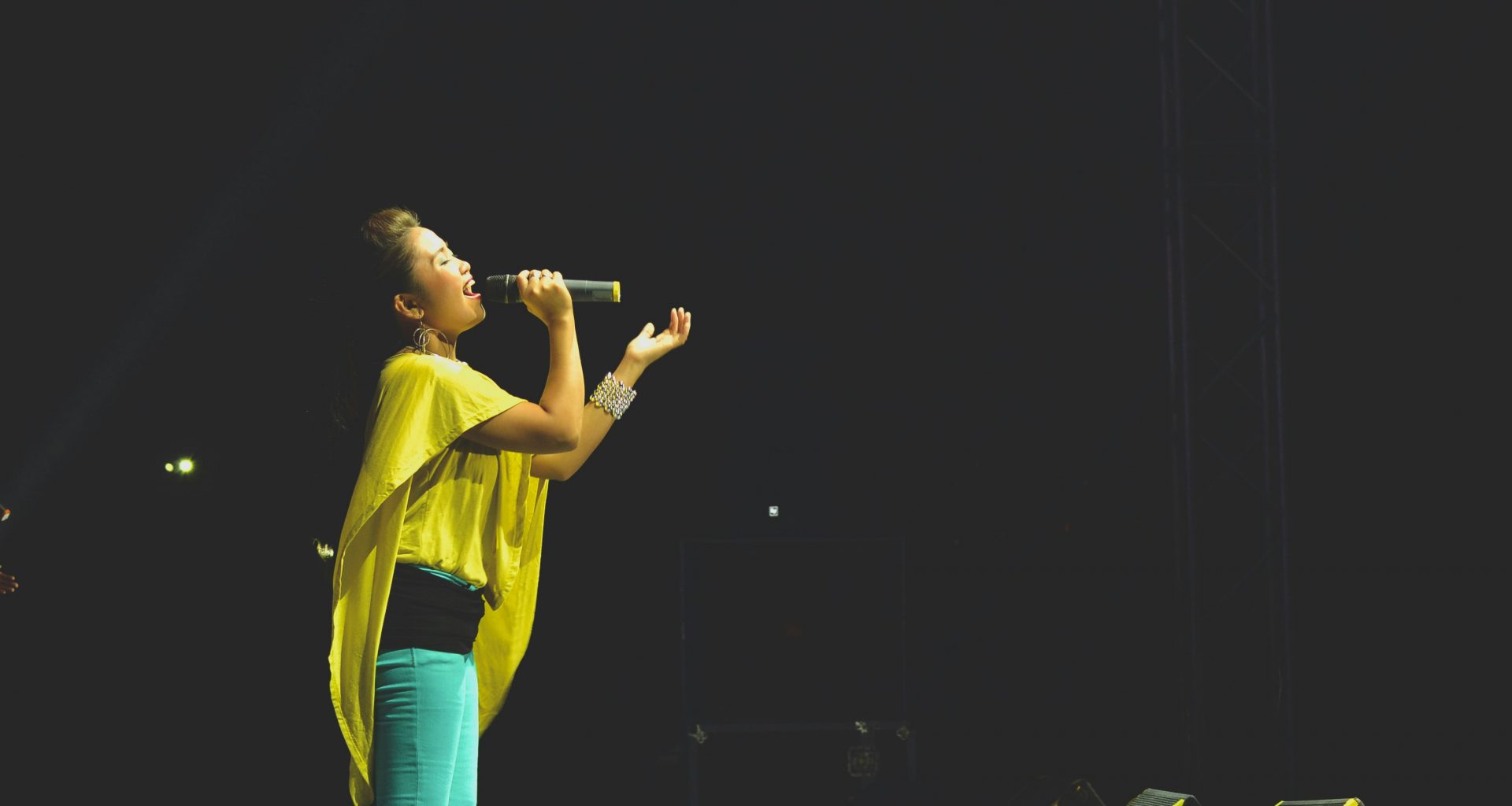 frau-mit-mikrofon-auf-der-buhne-NaTzgXieUlo