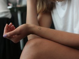 frau-zeigt-herz-handgelenk-tattoo-uMliNEGzYbQ