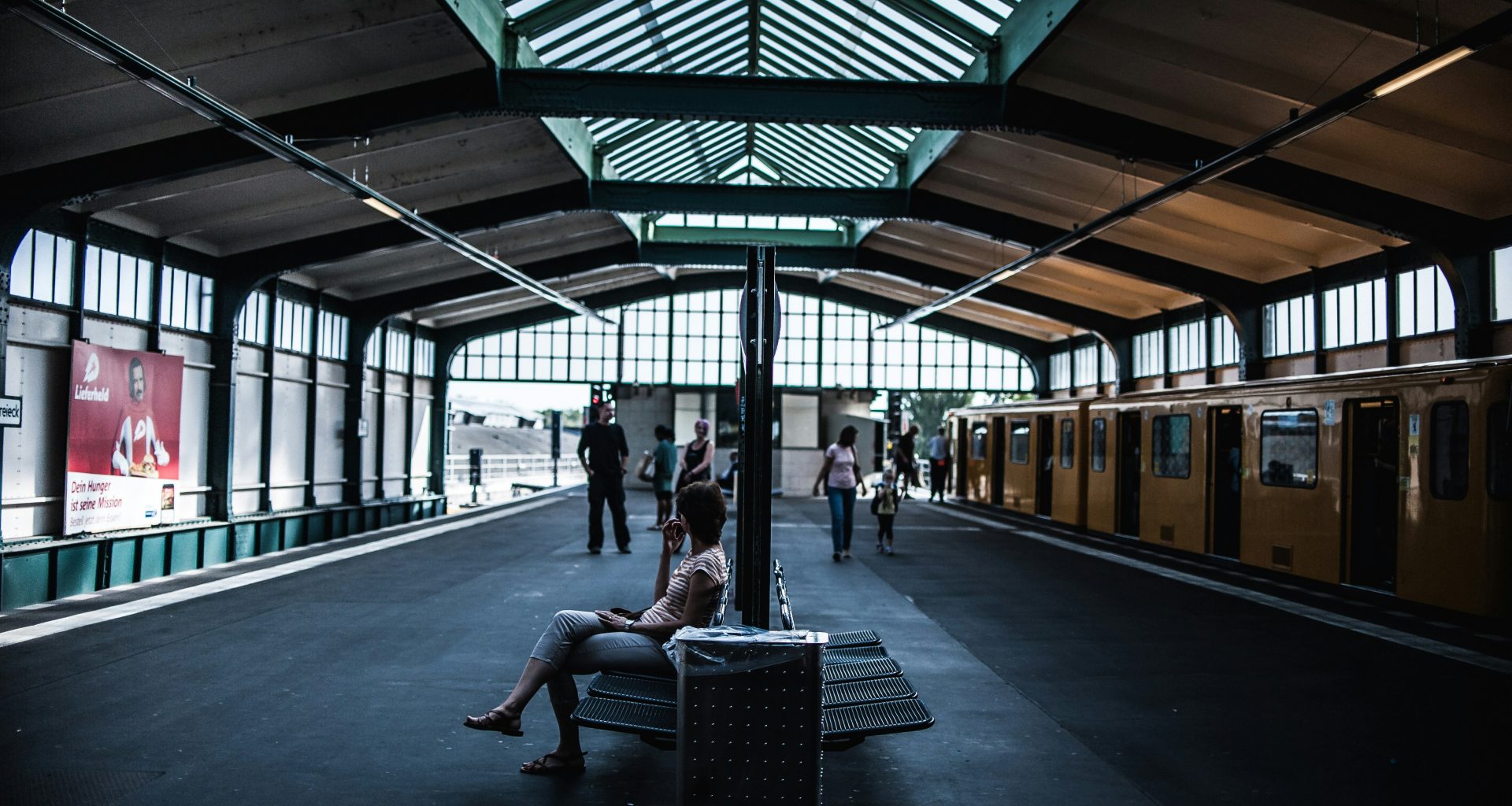 frau-sitzt-auf-stuhl-im-bahnhof-wOsybah2yAo
