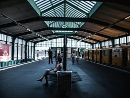frau-sitzt-auf-stuhl-im-bahnhof-wOsybah2yAo