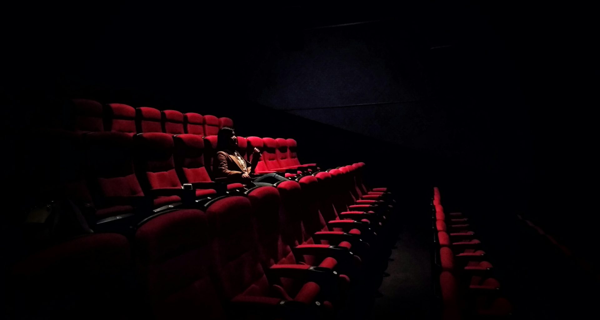 frau-sitzt-auf-rotem-klappsessel-jLRIsfkWRGo