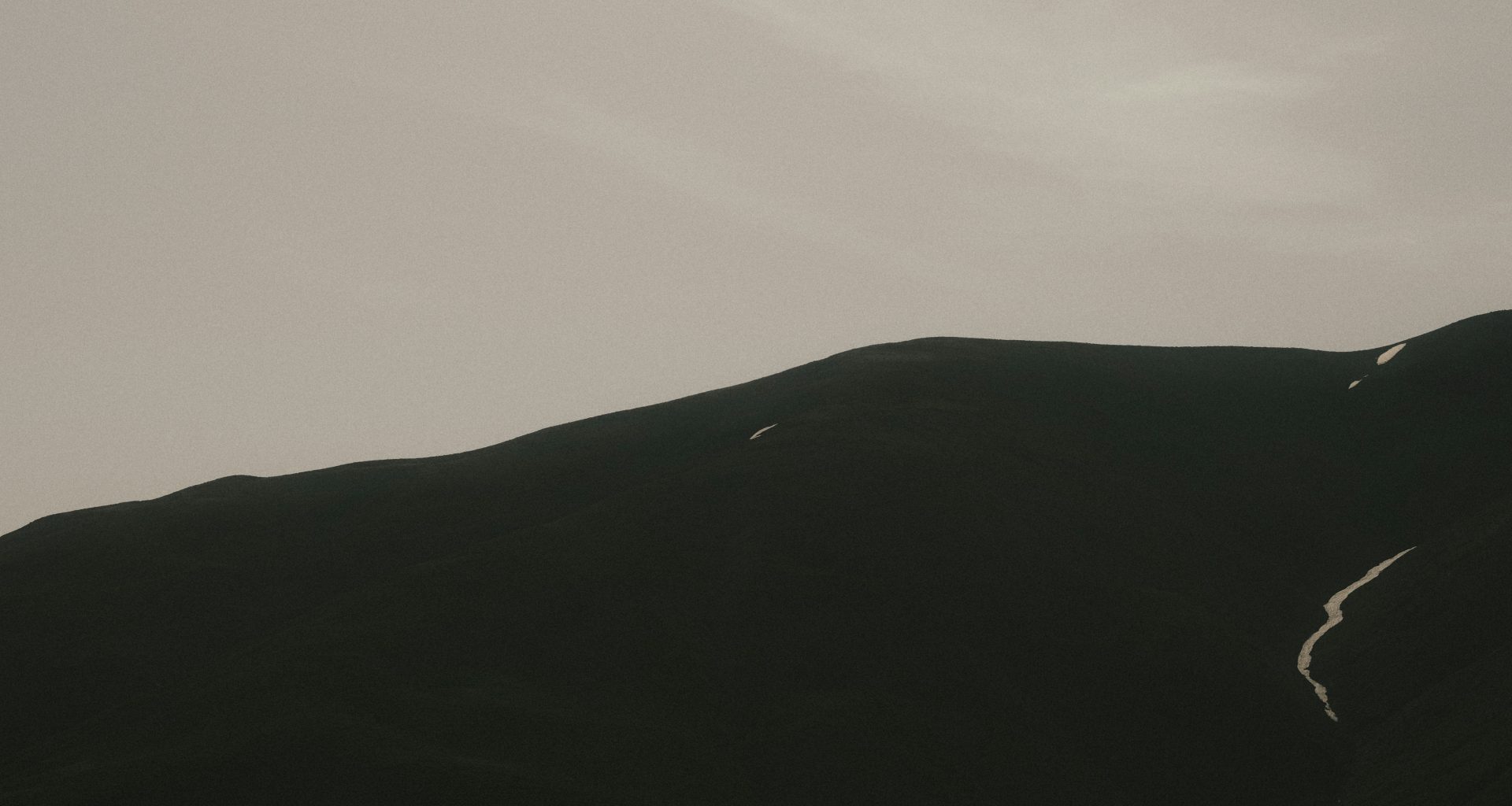 ein-vogel-der-uber-einen-berg-mit-himmelshintergrund-fliegt-hB47XP1aBYo