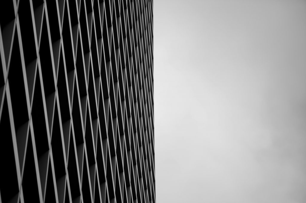 ein-schwarz-weiss-foto-eines-hohen-gebaudes-WJ6S61v3mwI