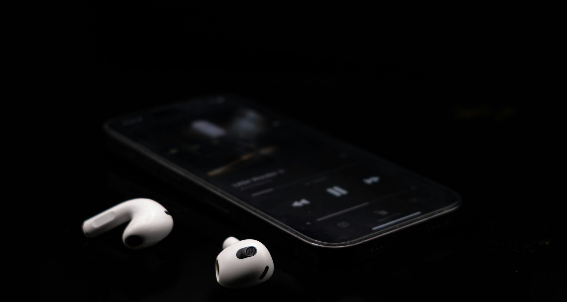 ein-schwarzes-handy-und-kopfhorer-auf-einem-tisch-Y-kBRcAhVeA